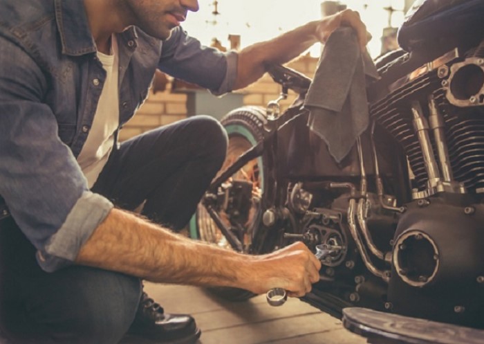 Mann repariert Motorrad mit Werkzeug