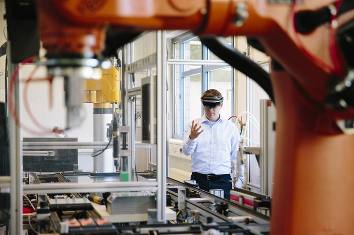 Mann mit VR-Brille arbeitet an einer Fertigungsmaschine